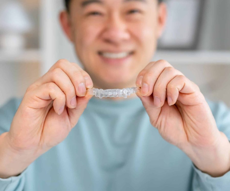 Young,Smiling,Man,Holding,Invisalign,Braces,In,Clinic,,Dental,Healthcare