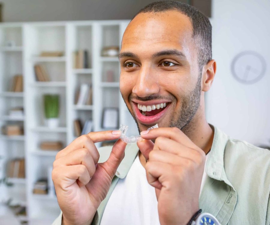 Young,Man,Holding,Dental,Aligner,At,Home,With,A,Happy