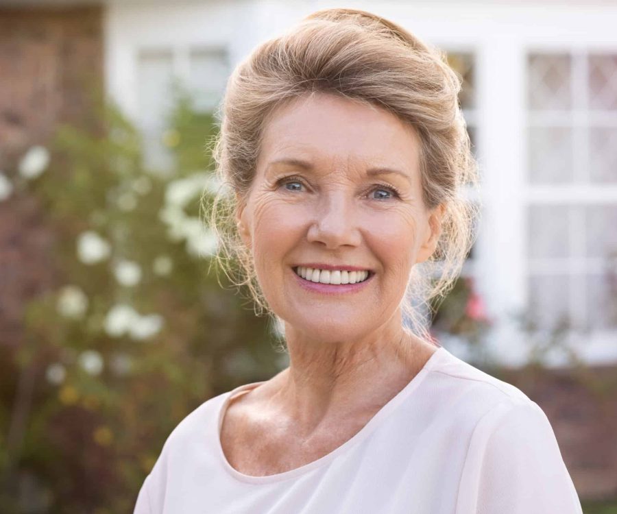 Happy,Senior,Woman,Standing,Outside,Her,House.,Content,Woman,Smiling